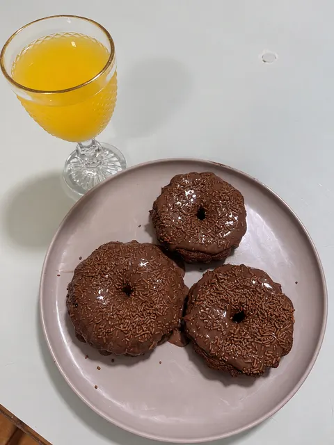 Bolinhos com cobertura de chocolate e granulado.
