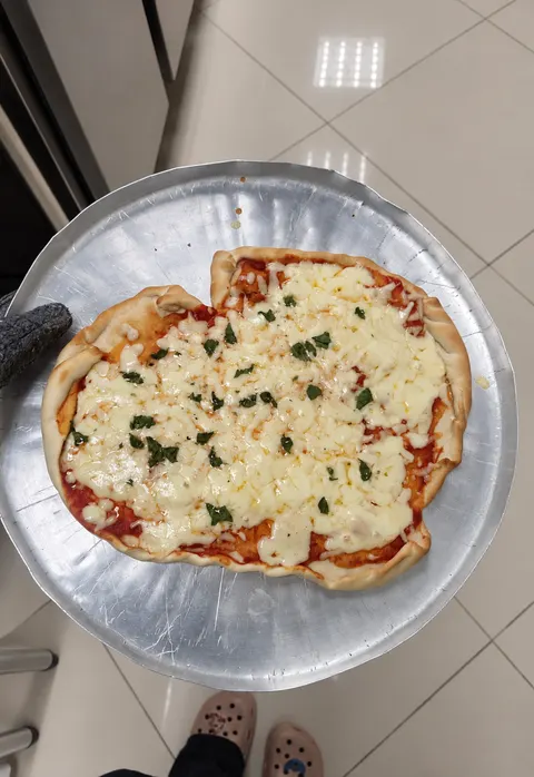 Outra pizza, com queijo e ervas, na assadeira.